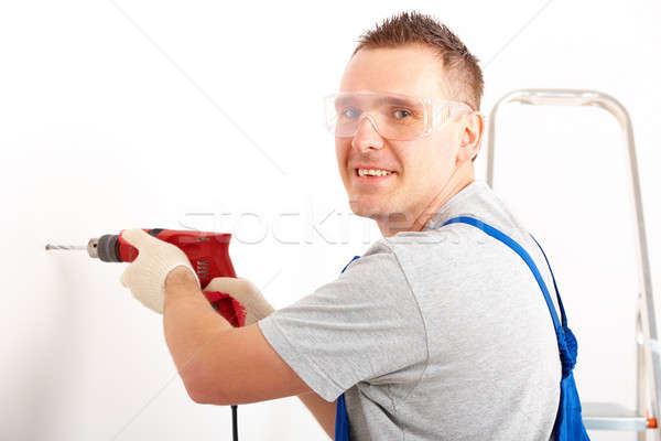 Homem perfuração buraco alegre trabalhando branco Foto stock © Amaviael