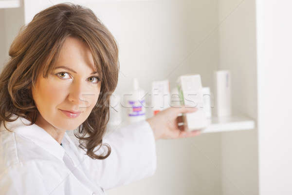 Jeune femme pharmacien bouteille médicaments permanent [[stock_photo]] © Amaviael