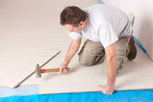 Stock photo: Worker installing a laminated flooring
