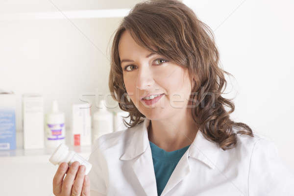 Young woman pharmacist with a bottle of drugs Stock photo © Amaviael