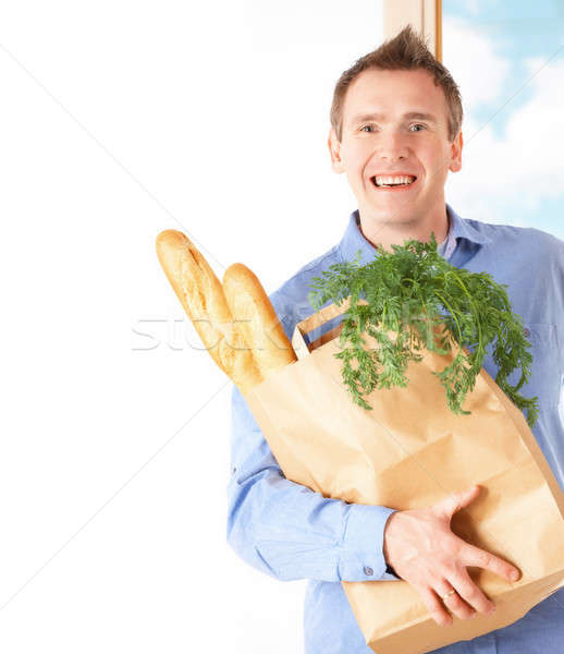 Imagine de stoc: Om · pungă · de · cumpărături · pâine · legume · hârtie