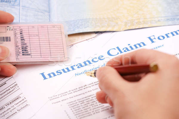 Stock photo: hand filling in insurance claim form