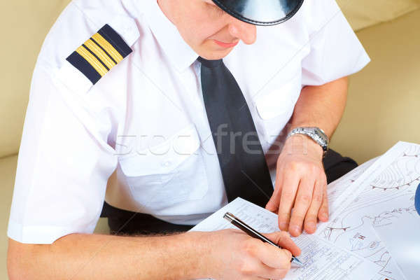 Vliegmaatschappij piloot vulling papieren glimlachend Stockfoto © Amaviael