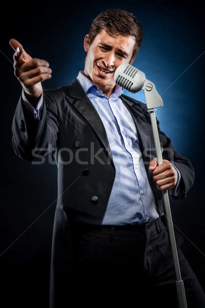 Man in elegant black jacket and blue shirt singing Stock photo © amok