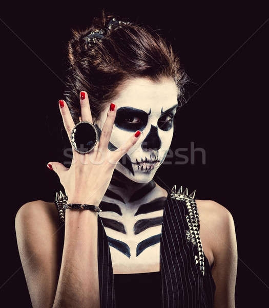 Stock photo: Woman with skeleton face art over black background