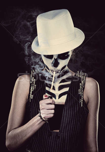 Woman with skeleton face art smoking over black background Stock photo © amok