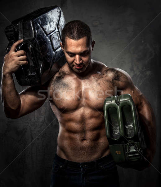 Muscular man with two metal fuel cans indoors Stock photo © amok