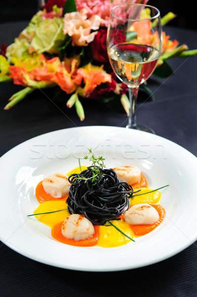 Stock photo: Black pasta with meat, garnished with sauce and  herbs close-up