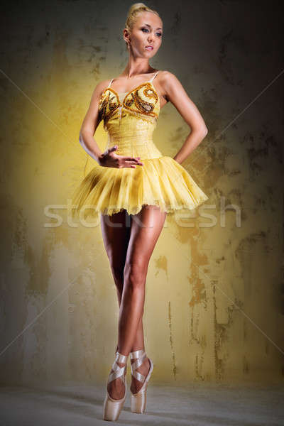 Beautiful ballerina in yellow tutu on point posing over obsolete wall Stock photo © amok