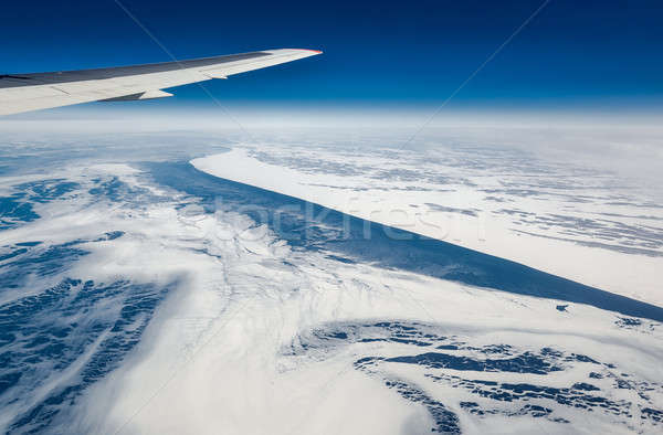 Stock photo: Wing of airplane flying above the Sea of Okhotsk