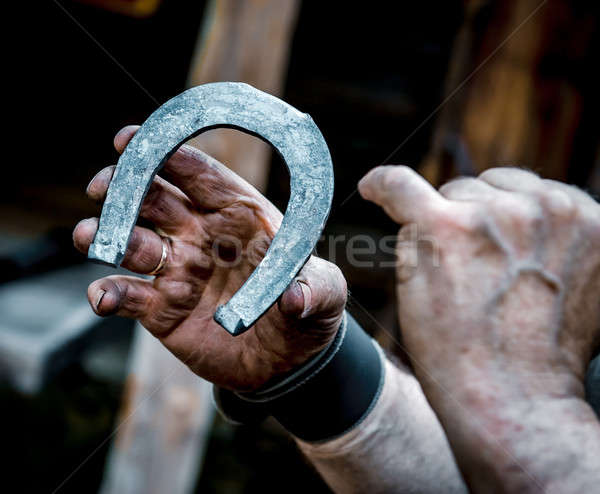 Blacksmith's dirty hands holding horseshoe  Stock photo © amok