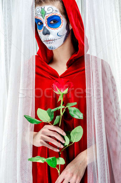 Day of the dead girl with sugar skull makeup holding red rose Stock photo © amok