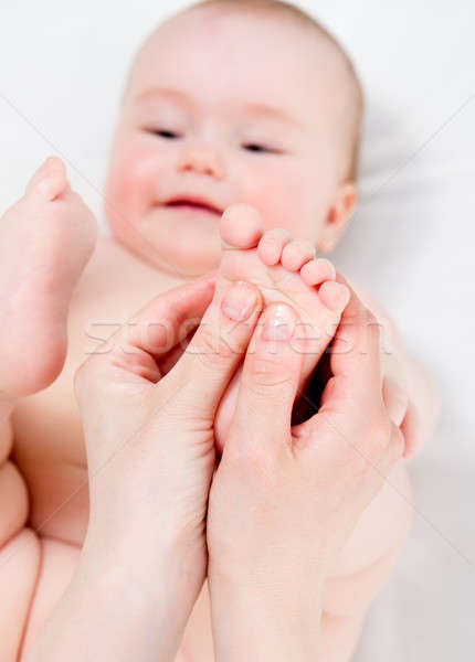 Stock photo: Mother massaging her baby girl