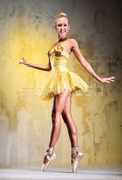 Beautiful ballerina in yellow tutu on point posing over obsolete wall Stock photo © amok