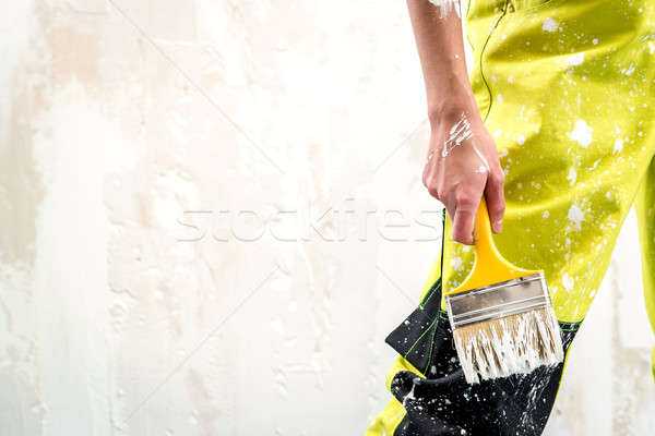 Female hand with paint brush over white obsolete background Stock photo © amok