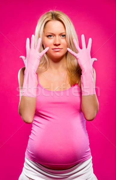 Pregnant attractive woman wearing rubber gloves posing over pink Stock photo © amok
