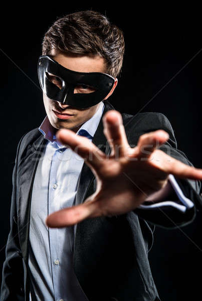 Stock photo: Elegant man wearing black mask posing indoors