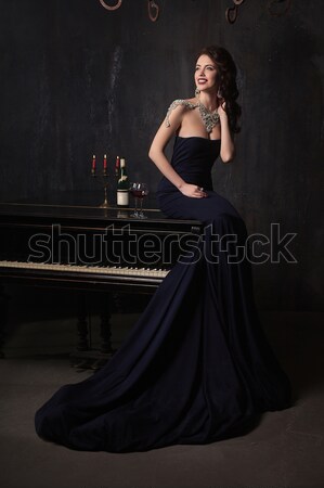 beautiful young woman in black dress next to a piano with candelabra candles and wine, dark dramatic Stock photo © andreonegin