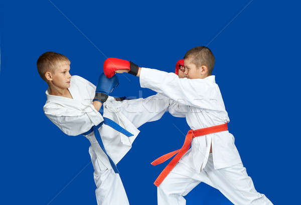 Boys in karategi are beating kick hand and leg Stock photo © Andreyfire