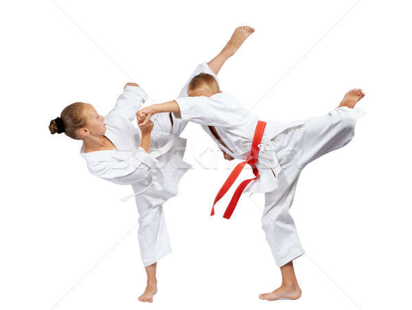 Mavashi geri and gyaku-tsuki beats sportsmens in karategi Stock photo © Andreyfire