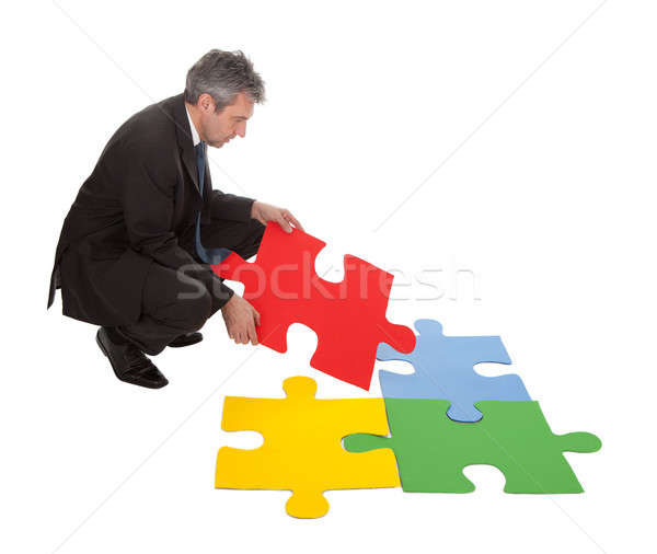 Senior businessman assembling a jigsaw puzzle Stock photo © AndreyPopov