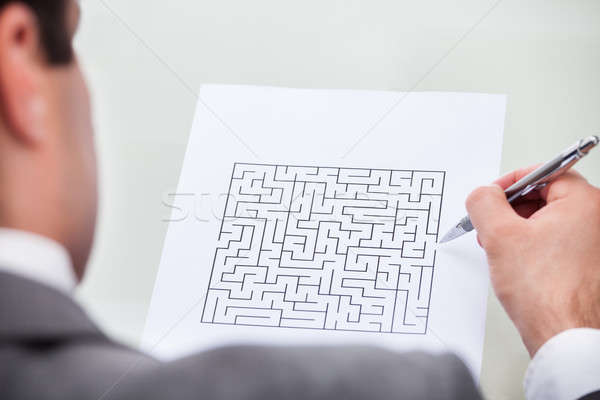Businessman Looking At Maze Puzzle Holding Pen Stock photo © AndreyPopov