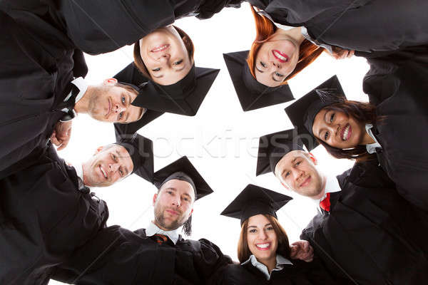 Graduate students standing in circle leaning towards camera Stock photo © AndreyPopov