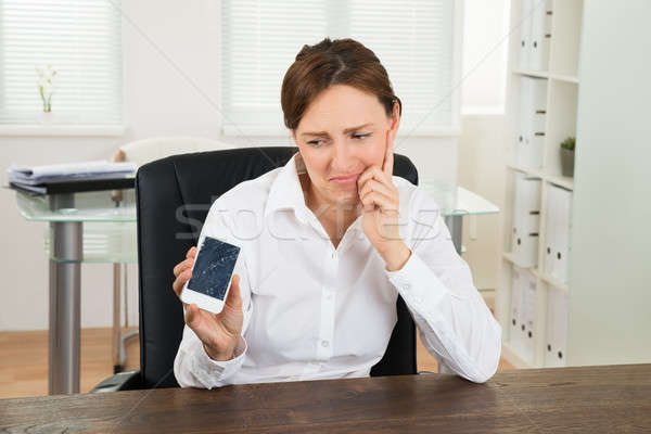 Businesswoman Looking At Broken Mobile Phone Stock photo © AndreyPopov