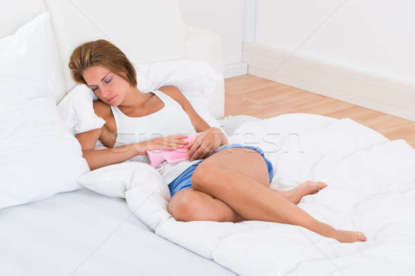 Mujer agua caliente bolsa cama jóvenes mujer hermosa Foto stock © AndreyPopov