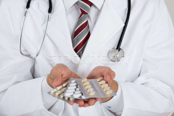 Midsection Of Doctor Holding Blister Packs Stock photo © AndreyPopov