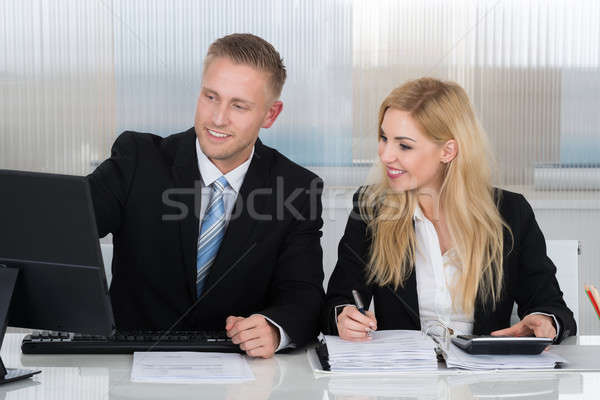 Business People With Paperwork Discussing Over Computer At Desk Stock photo © AndreyPopov