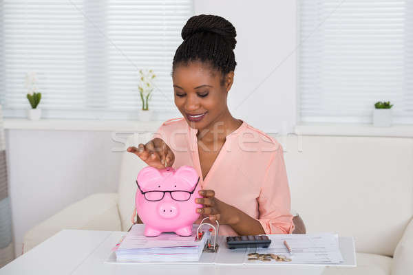 Woman Inserting Coin In Piggybank Stock photo © AndreyPopov