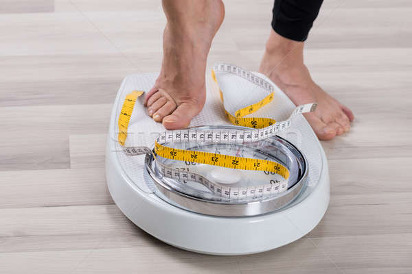 Person Feet Standing On Weighing Scale Stock photo © AndreyPopov