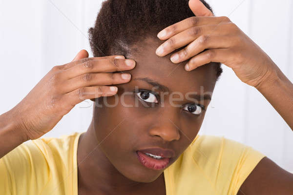 Stock photo: Woman Looking At Pimple On Forehead