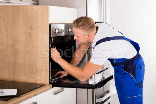 Technikus javít sütő fiatal férfi konyha Stock fotó © AndreyPopov