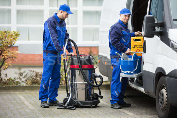 Two Male Janitor Unloading Cleaning Equipment From Vehicle Stock photo © AndreyPopov