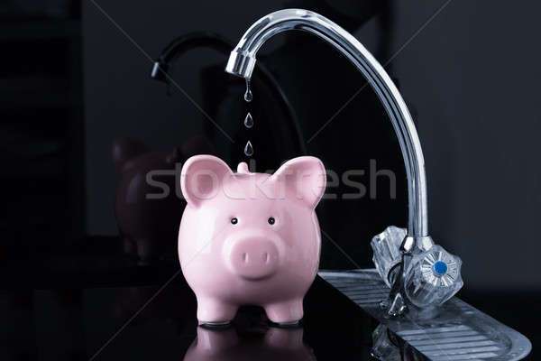 Falling Dripping Water Drop From The Faucet Inside The Piggybank Stock photo © AndreyPopov