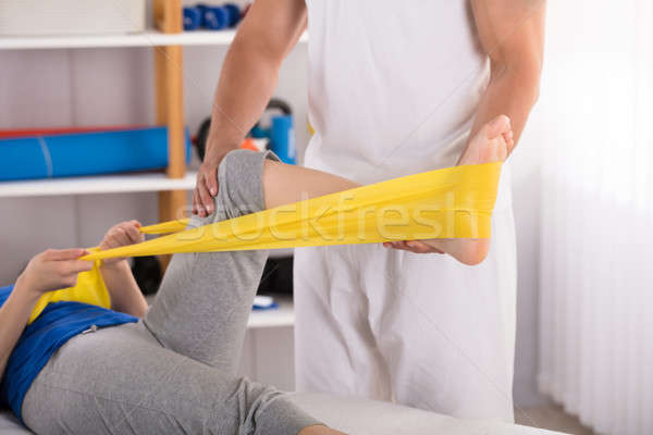 Physiotherapist Giving Leg Treatment With Exercise Band Stock photo © AndreyPopov