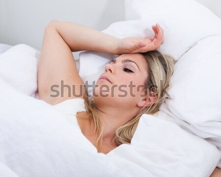 Upset woman lying on bed Stock photo © AndreyPopov