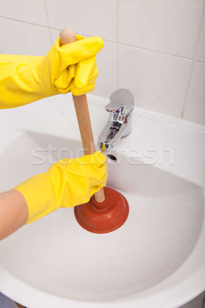 Person's Hand Pressing Plunger In Sink Stock photo © AndreyPopov