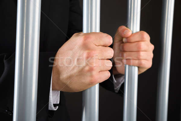 Close-up Of Businessman Holding Bars In Jail Stock photo © AndreyPopov