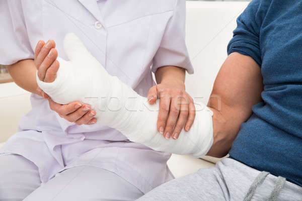 Female Doctor Holding Fractured Hand Of A Patient Stock photo © AndreyPopov