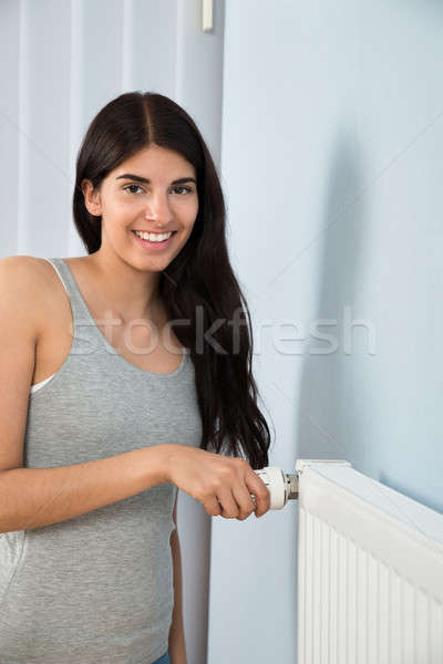 Zdjęcia stock: Kobieta · termostat · radiator · młodych · szczęśliwy · domu