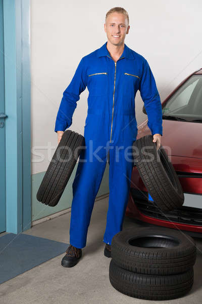 Mecânico pneus jovem sorridente em pé Foto stock © AndreyPopov