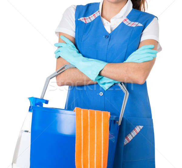 Femminile lavoratore secchio piedi braccia incrociate bianco Foto d'archivio © AndreyPopov