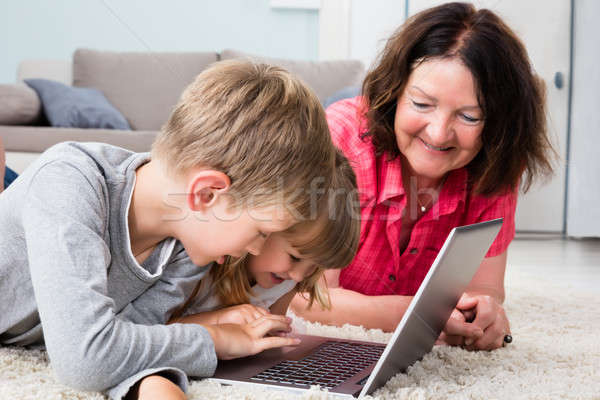 Többgenerációs család laptopot használ otthon gyerekek számítógép játék Stock fotó © AndreyPopov