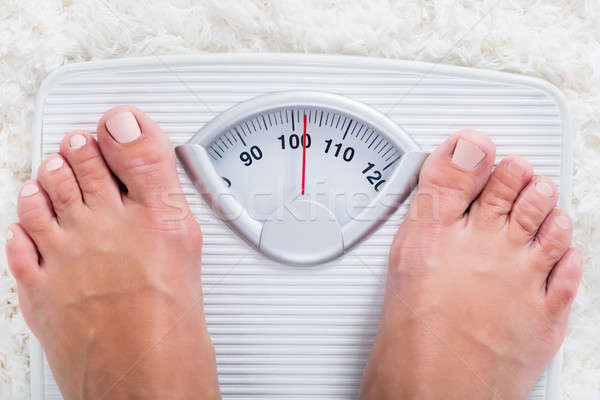 Person Standing On Weighing Scale Stock photo © AndreyPopov