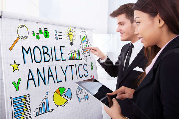 Businesspeople Discussing Mobile Analytics On Flipchart Stock photo © AndreyPopov