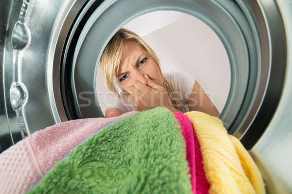 Woman Inserting Stinking Clothes In Washing Machine Stock photo © AndreyPopov