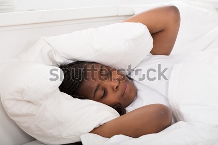 Girl Covering Her Ears With Pillow Stock photo © AndreyPopov
